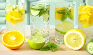 a group of glasses with water and fruit on a table