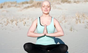 Kumsalda yoga yapan kanser hastası kadın