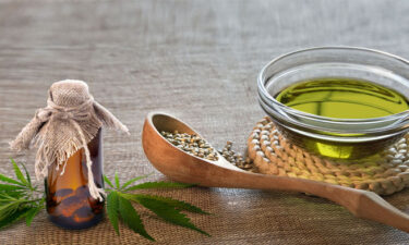 Kenevir Yağı ve tohumları. Tahta kaşık ve şişe içerisinde