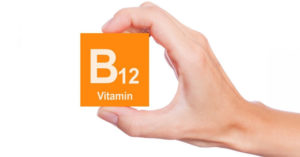 B12 Vitamini görselini elinde tutan adam