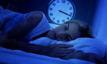 Uykusuzlukla Başa Çıkmanın Yolları: En İyi Uyku Alışkanlıkları ve Öneriler 55 a woman lying in bed with a clock in the background