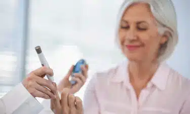 parmaktan şeker ölçümü yapan yaşlı kadın