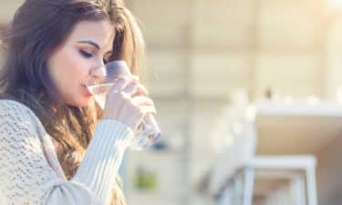 a woman drinking water from a glass